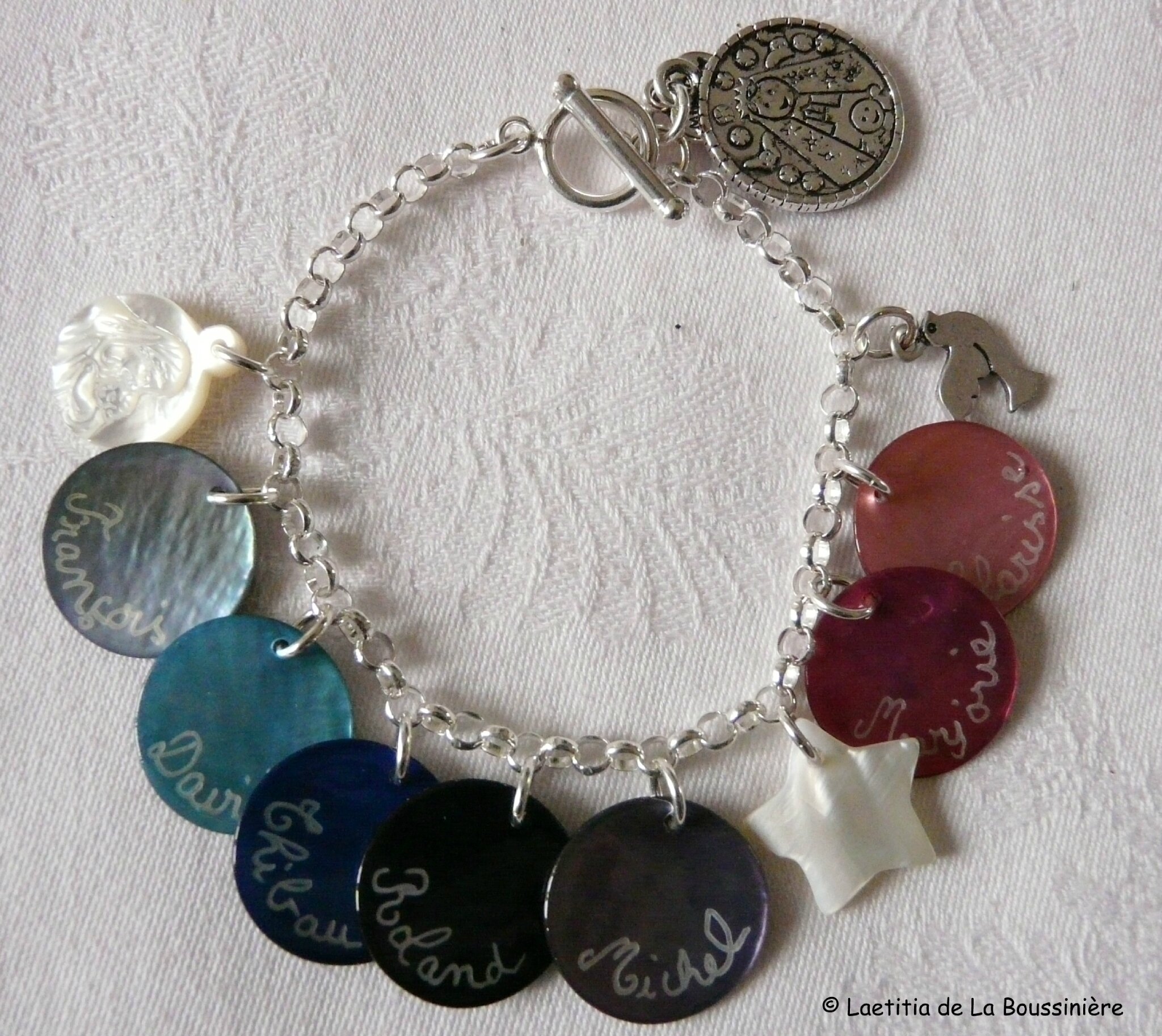 Bracelet sur chaîne argent massif composé de médailles en nacre gravées et de breloques nacre et